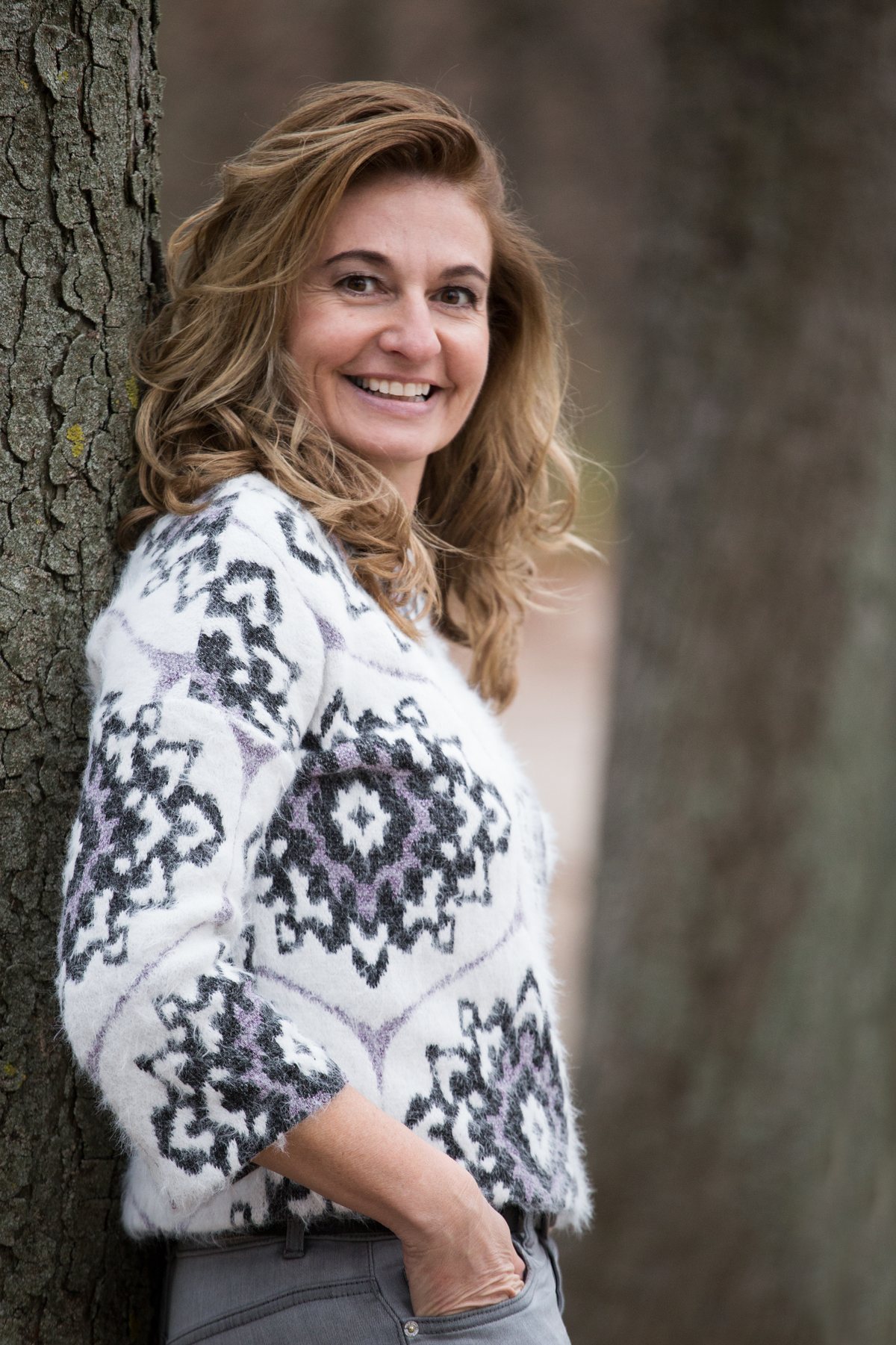 Bianca Ortner, eingetragene Mediatorin in Mödling, lehnt lächelnd an einem Baum
